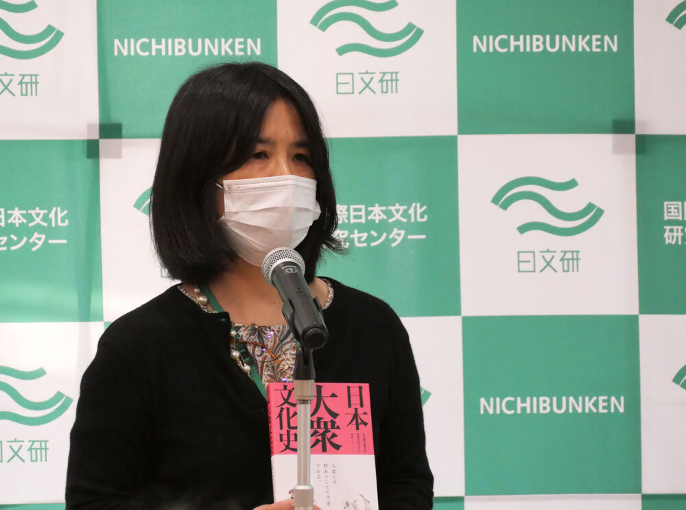 大衆文化研究叢書を手に説明する安井教授